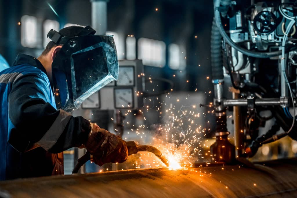 Man welding in a factory setting